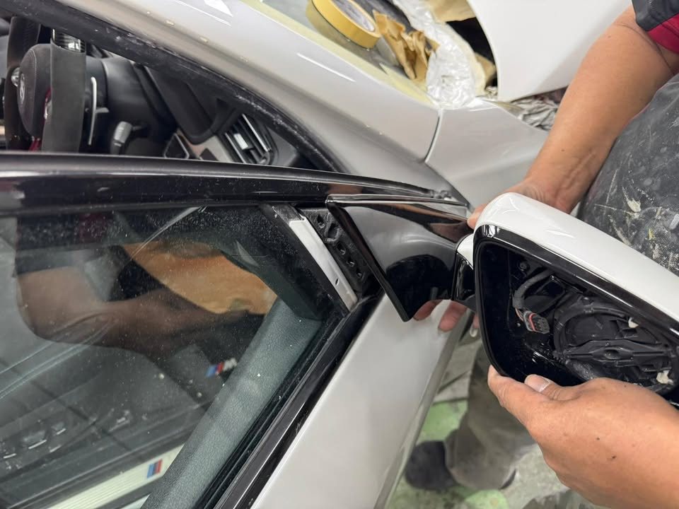 Side mirror being taken off the M5's door.