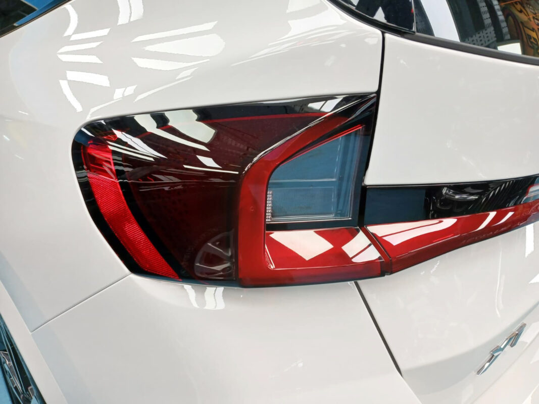 The coated bonnet of the BMW X1 under workshop lighting.