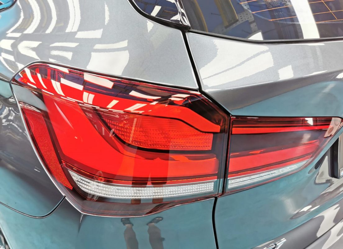 The coated bonnet of the BMW X1 under workshop lighting.