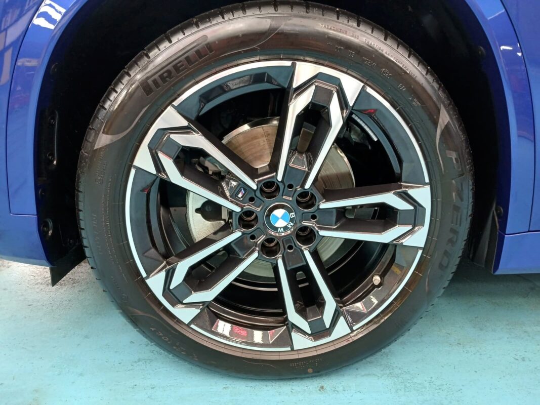 The coated bonnet of the BMW X1 under workshop lighting.