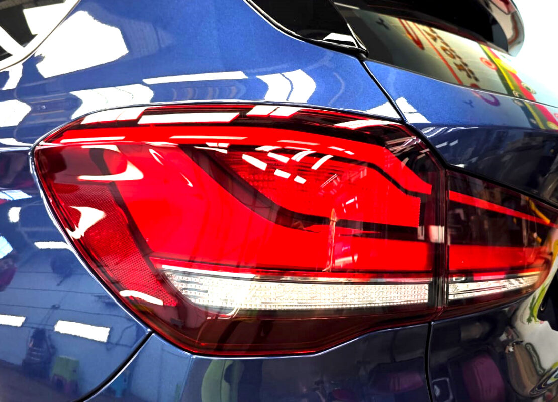 The coated bonnet of the BMW X1 under workshop lighting.