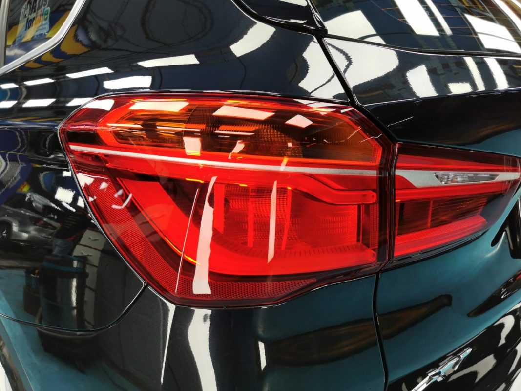 The coated bonnet of the BMW X1 under workshop lighting.