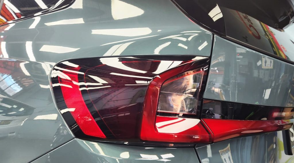 The coated bonnet of the BMW X1 under workshop lighting.