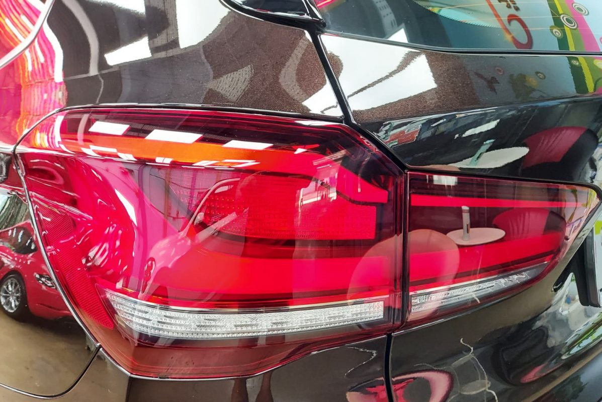 The coated bonnet of the X1 under workshop lighting.