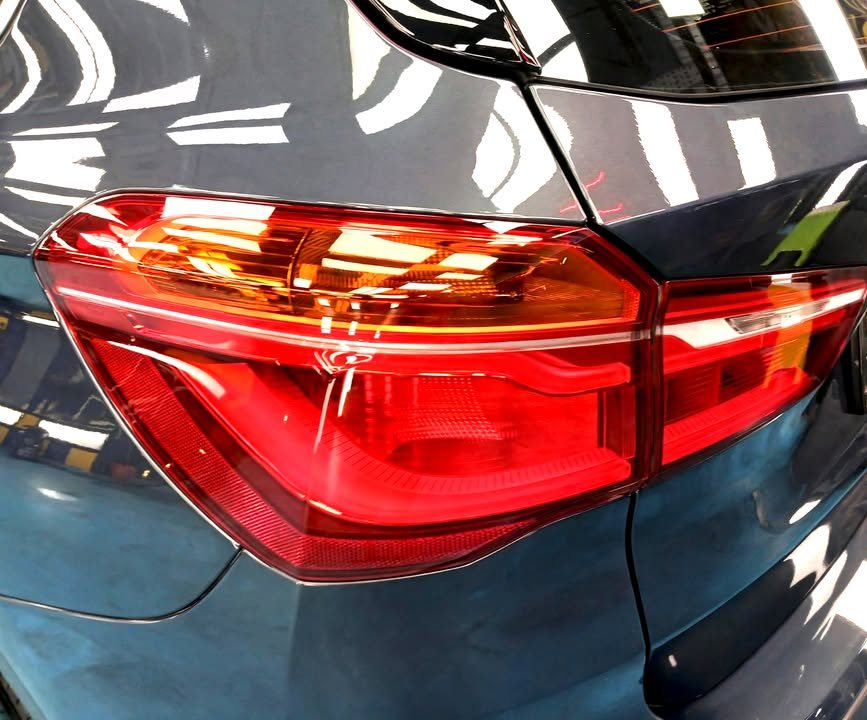 Close-up of the X1's red tail light against the blue paint.