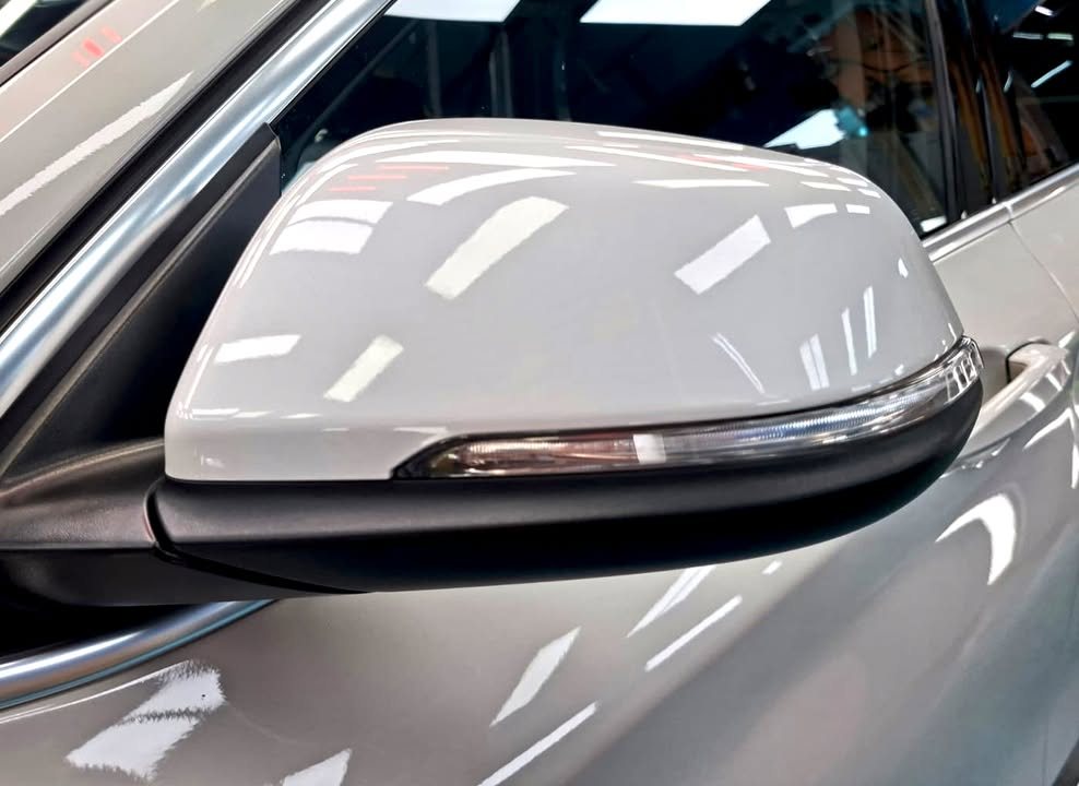 White side mirror cap reflecting the workshop lights.
