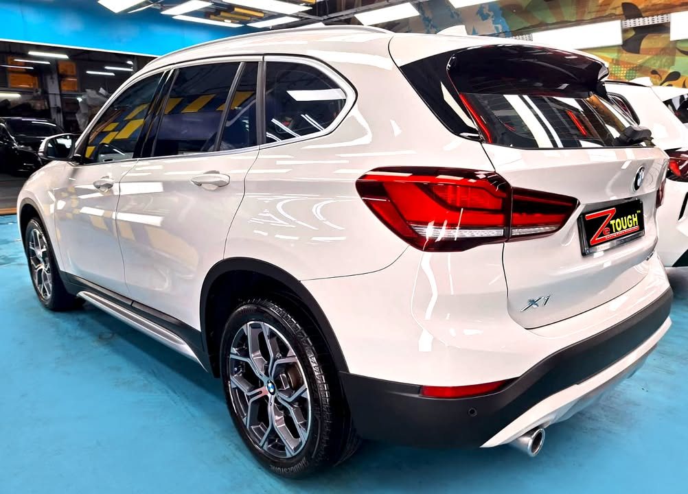 Rear three-quarter view of the white X1 showing the tail lights and X1 badge.