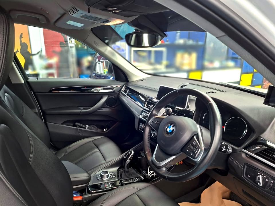 Interior with black leather seats and the BMW steering wheel.