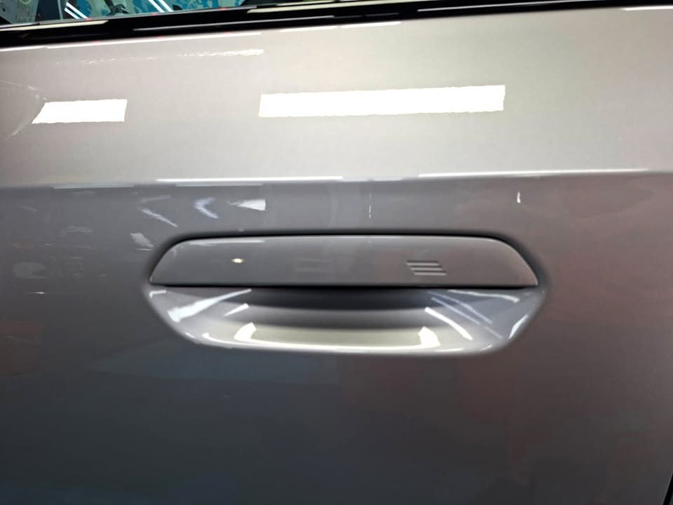 Close-up of the grey door panel around the door handle.