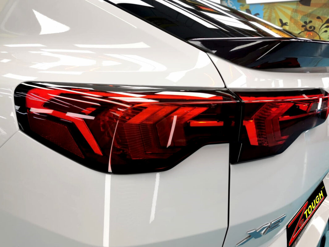 The coated bonnet of the BMW X2 under workshop lighting.