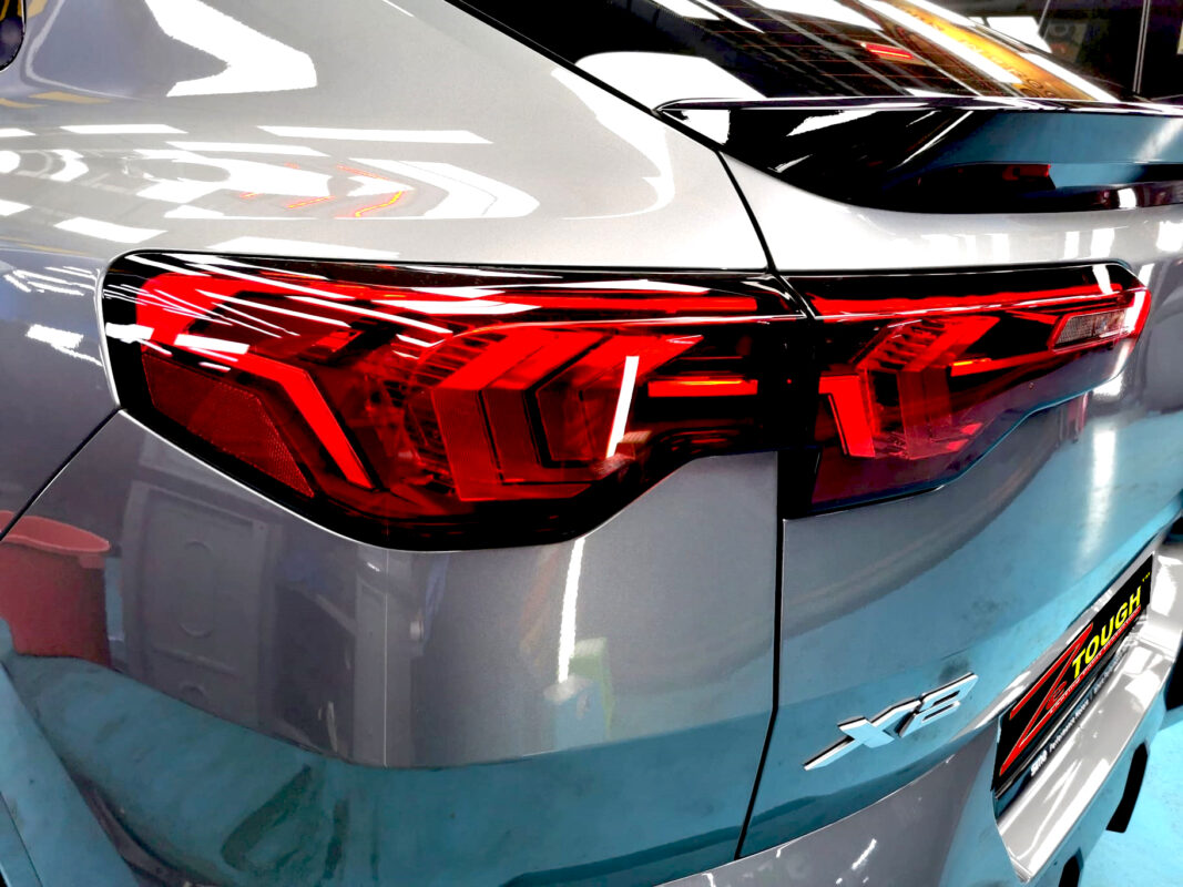 The coated bonnet of the BMW X2 under workshop lighting.