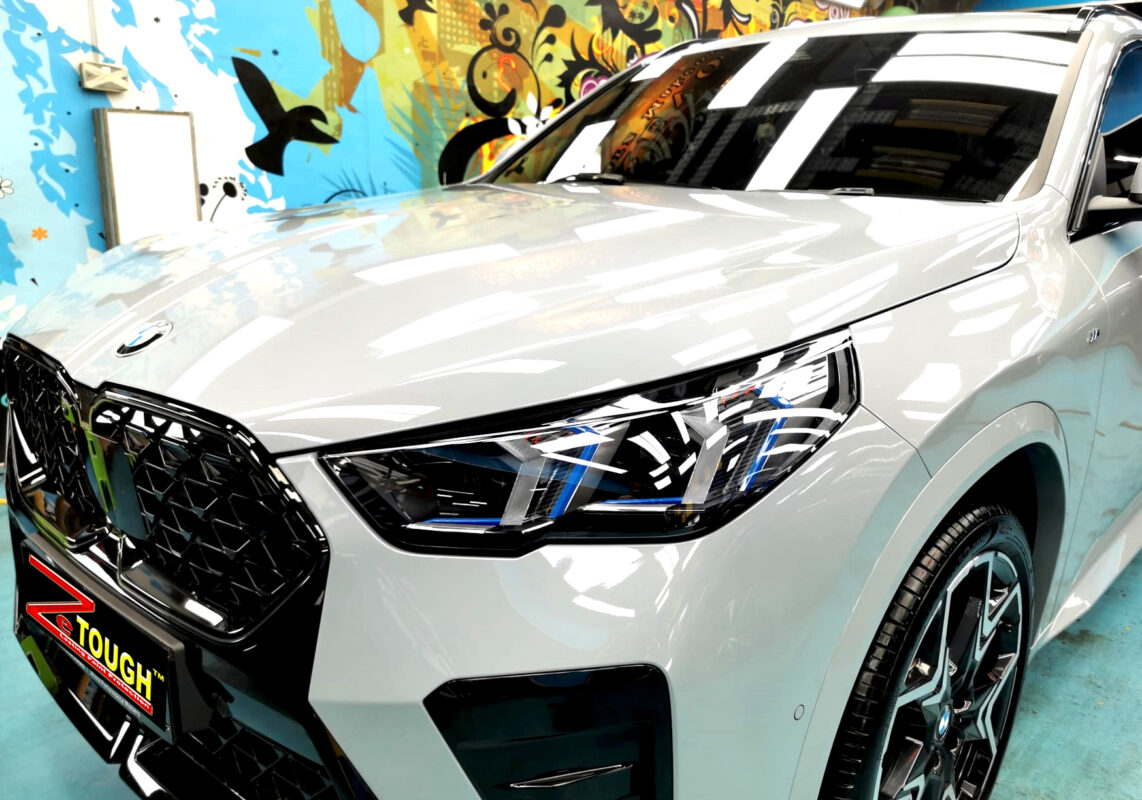 The BMW X2's coated paintwork under workshop lighting.