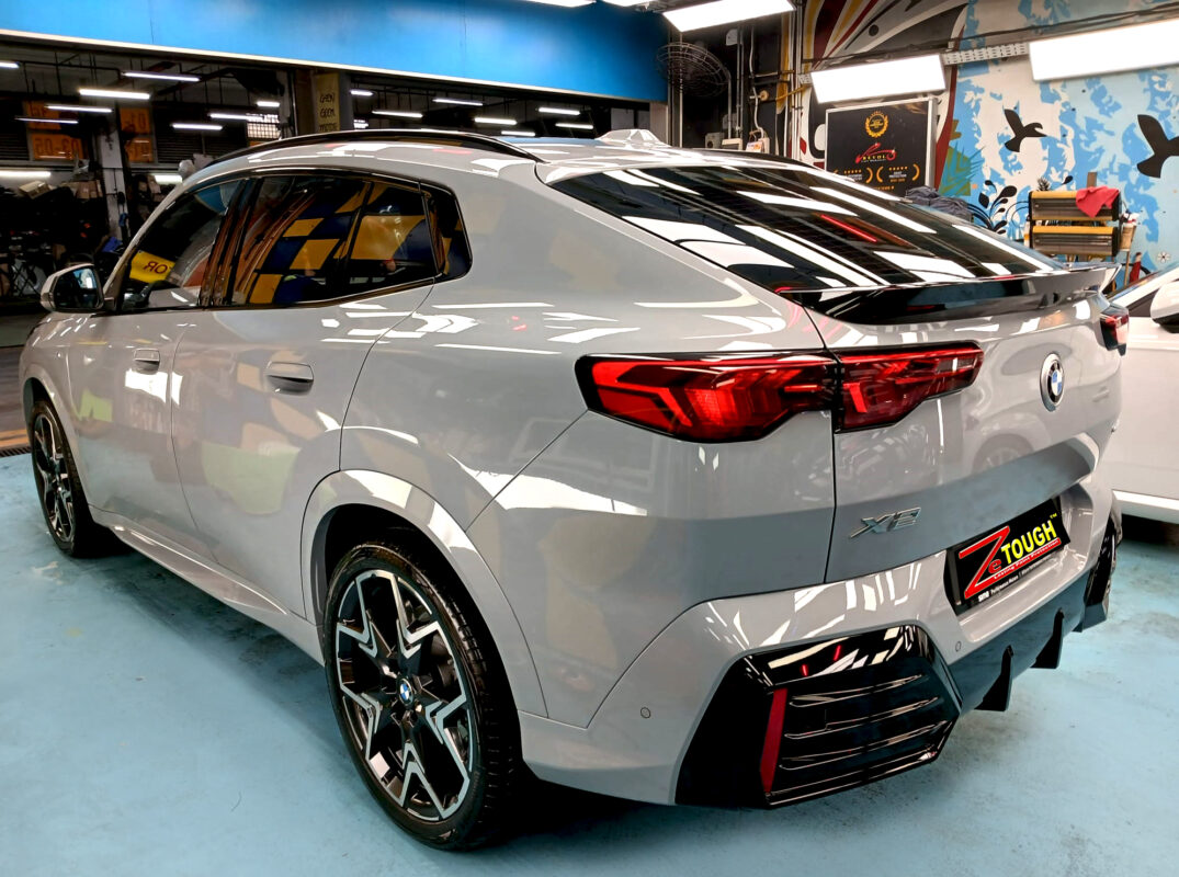 The coated bonnet of the BMW X2 under workshop lighting.