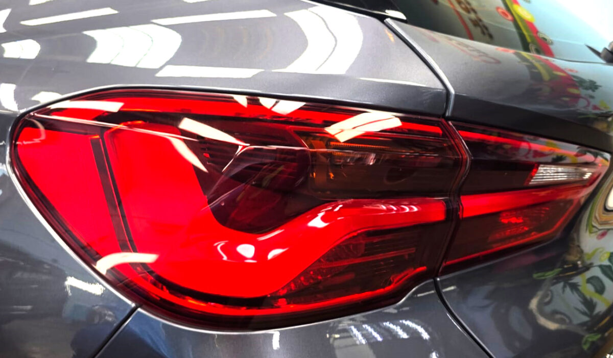 The coated bonnet of the BMW X2 under workshop lighting.