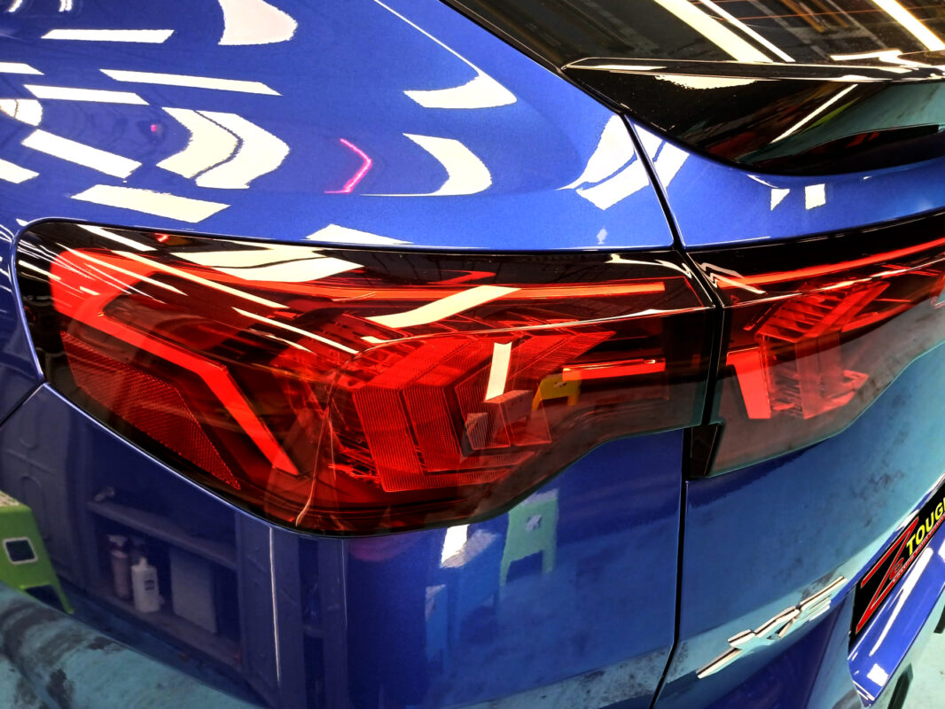 The coated bonnet of the BMW X2 under workshop lighting.