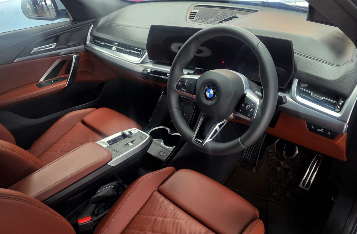 Reflections across the coated panels of the BMW X2.
