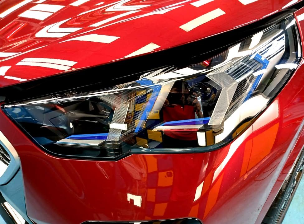 Close-up of the X2 headlight set into red paint.