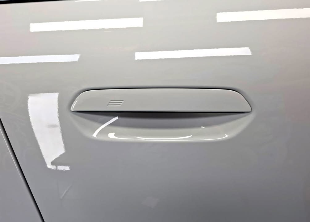 Flush door handle on the white door panel.