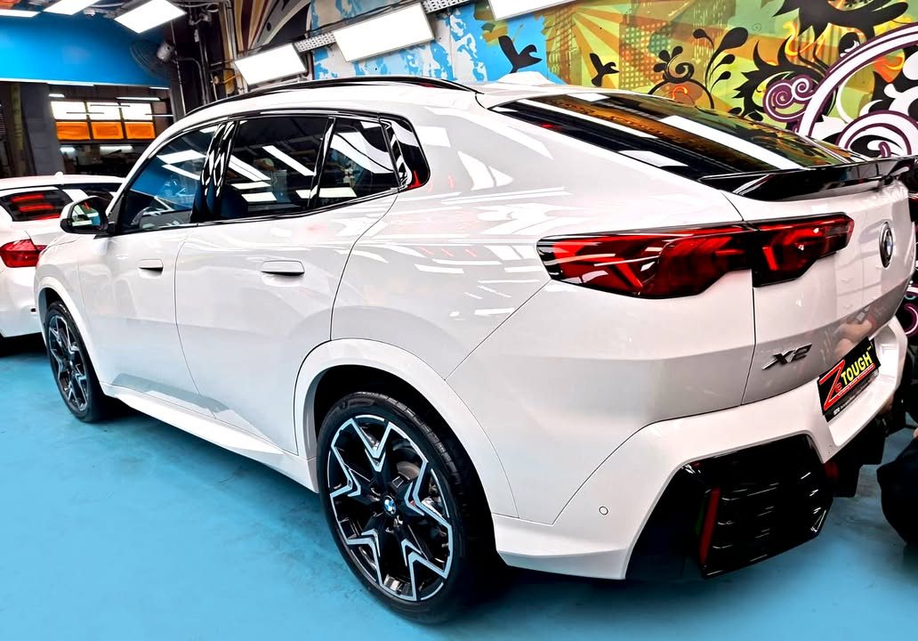 Rear three-quarter view of the white BMW X2 with a ZeTough plate.