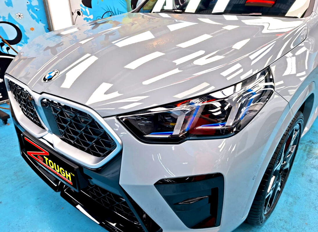 The BMW X2's coated paintwork under workshop lighting.