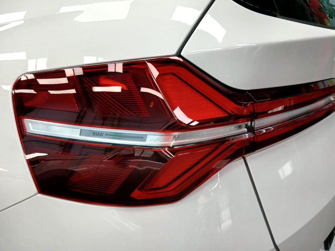 The coated bonnet of the BMW X3 under workshop lighting.