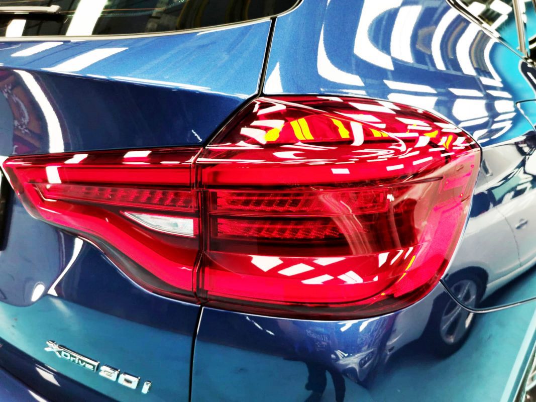 The coated bonnet of the BMW X3 under workshop lighting.