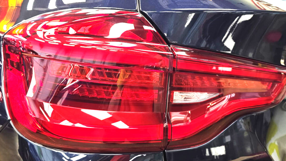 The coated bonnet of the BMW X3 under workshop lighting.