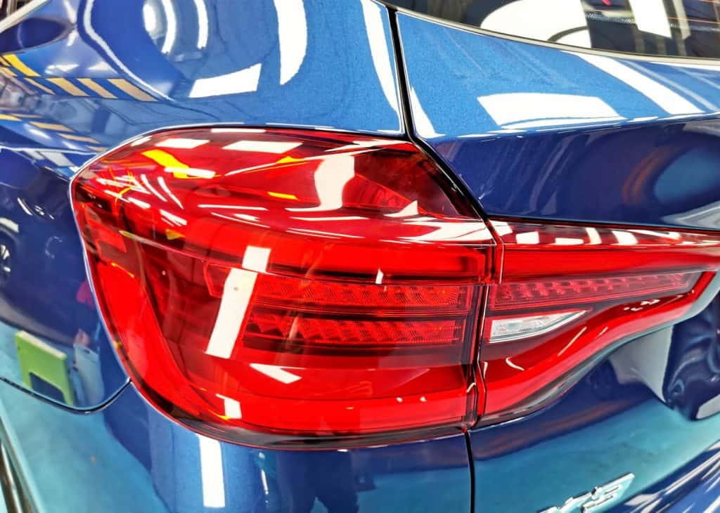 The coated bonnet of the BMW X3 under workshop lighting.