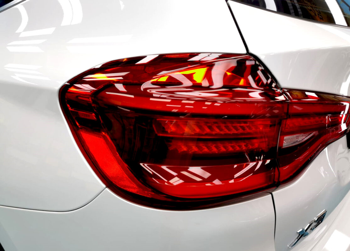The coated bonnet of the BMW X3 under workshop lighting.
