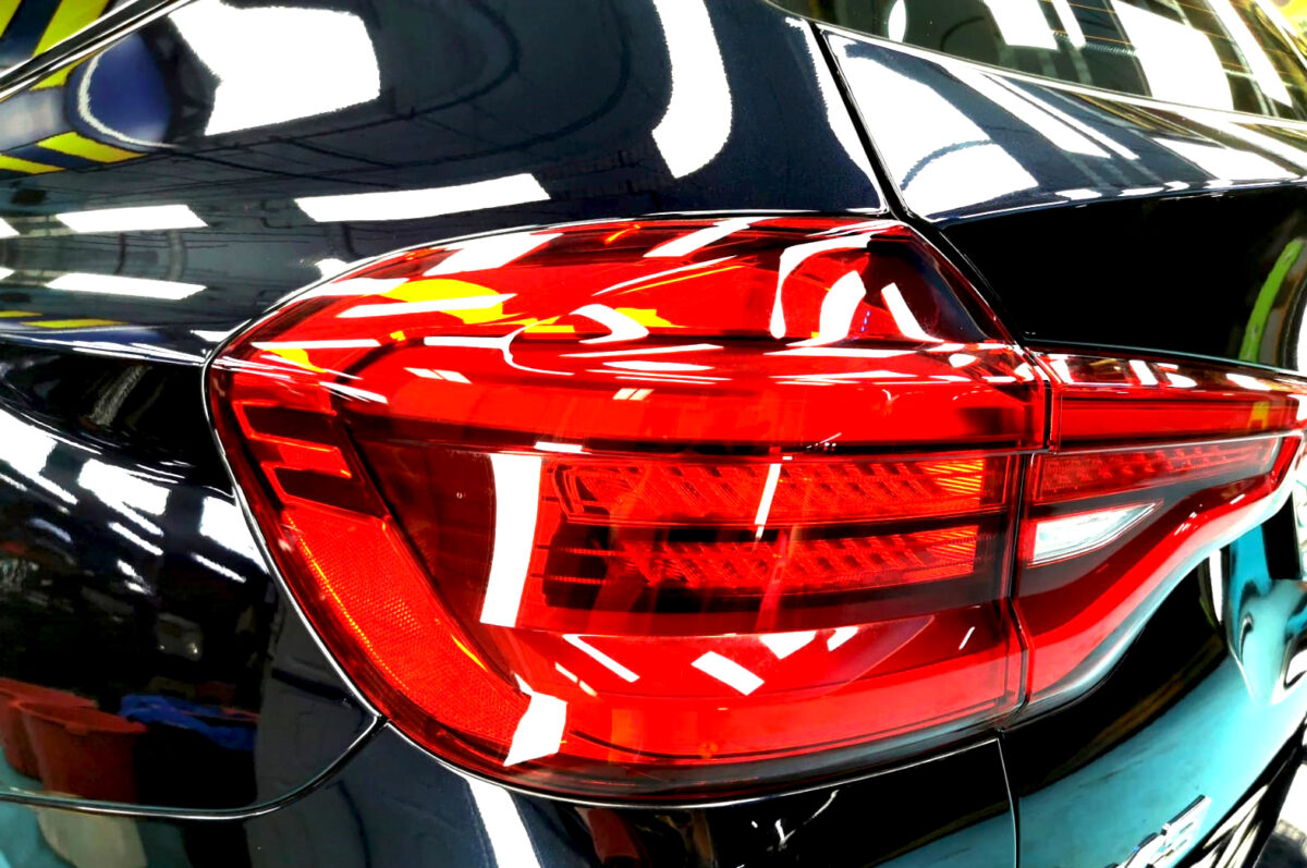 The coated bonnet of the BMW X3 under workshop lighting.