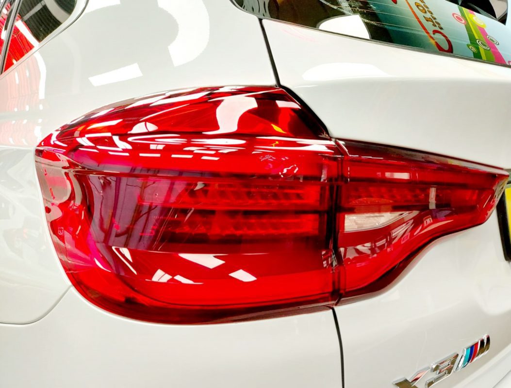 The coated bonnet of the BMW X3 under workshop lighting.
