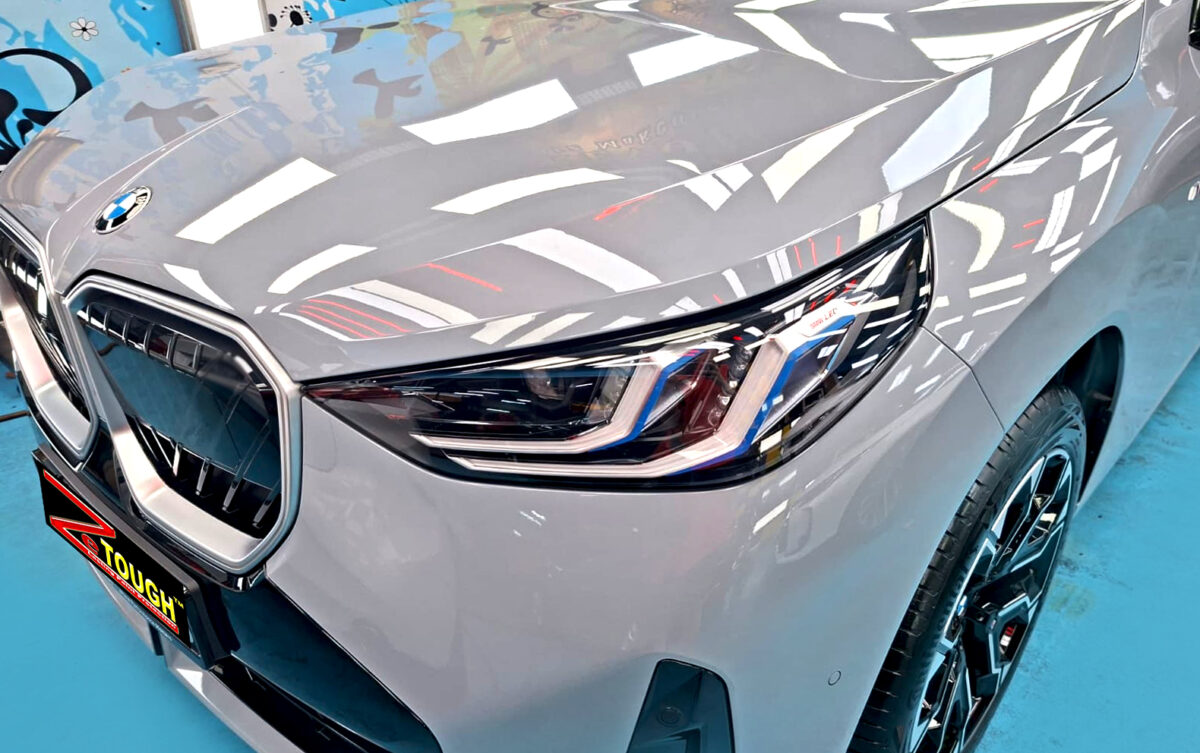 The BMW X3's coated paintwork under workshop lighting.