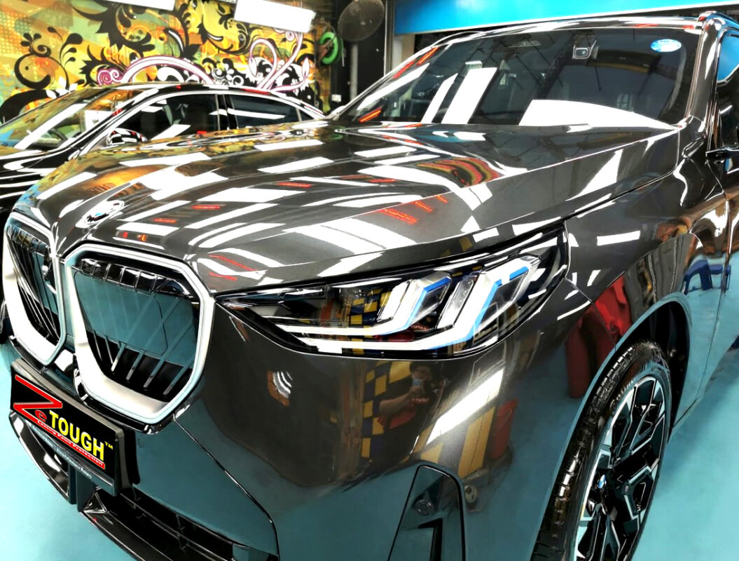 The BMW X3's coated paintwork under workshop lighting.
