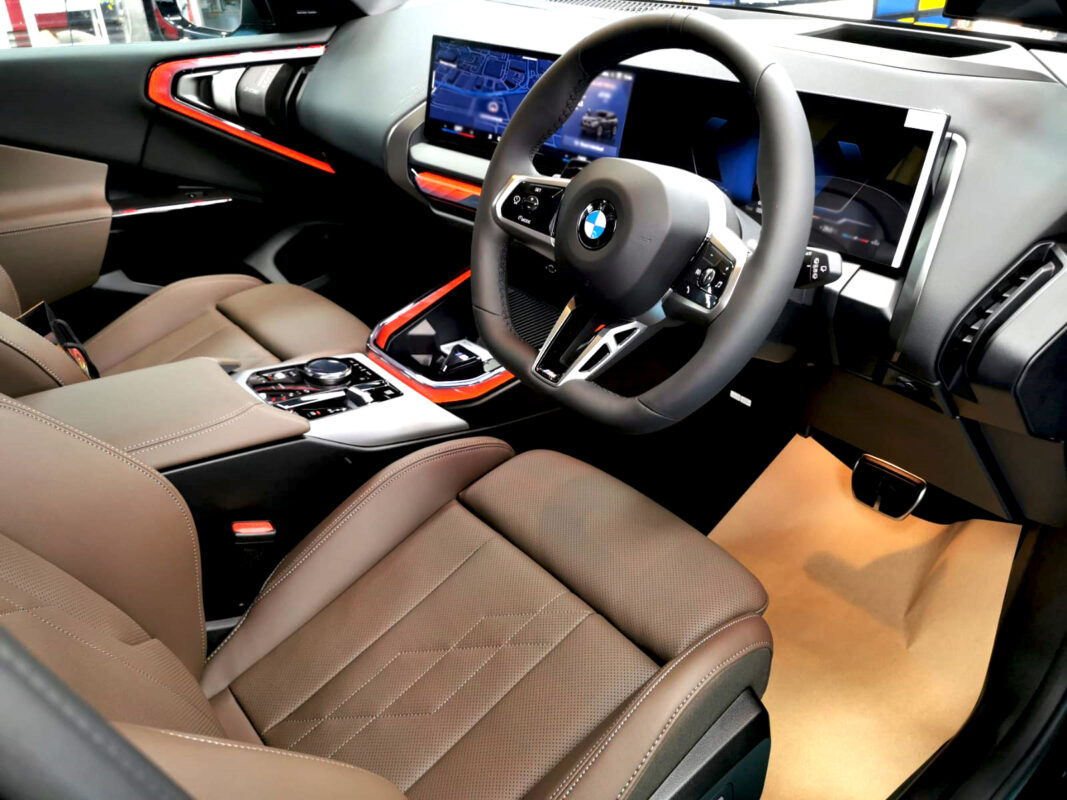 Reflections across the coated panels of the BMW X3.