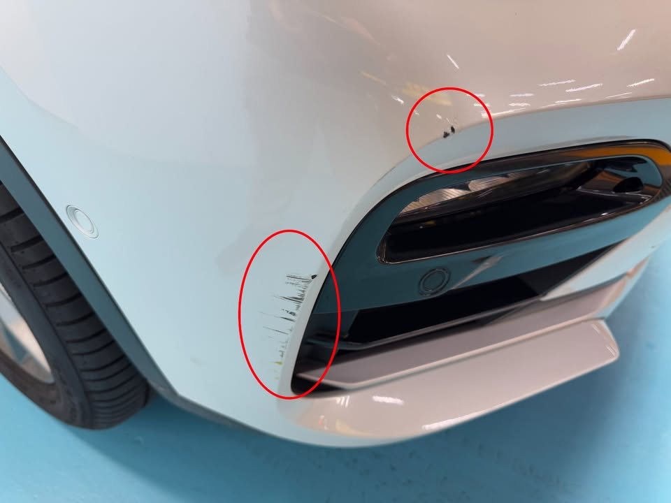 Scratches on the front bumper corner of the X4, circled in red.
