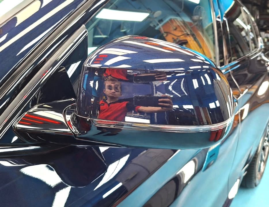 Dark blue mirror cap of the X4 reflecting the workshop.