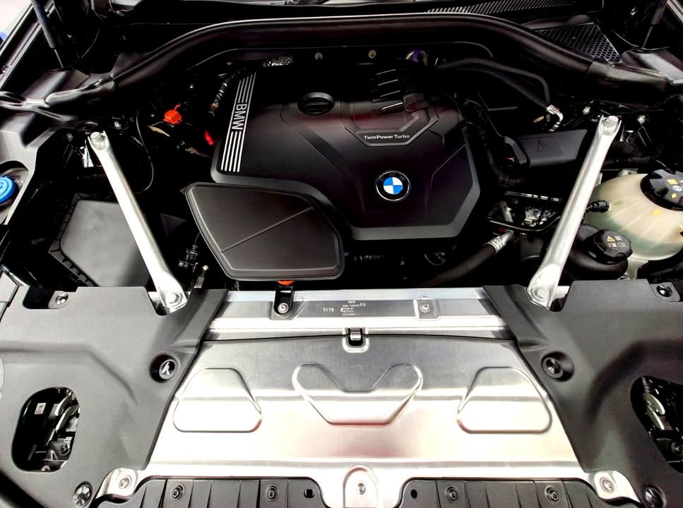 Clean engine bay of the BMW X4 with the engine cover and strut brace.