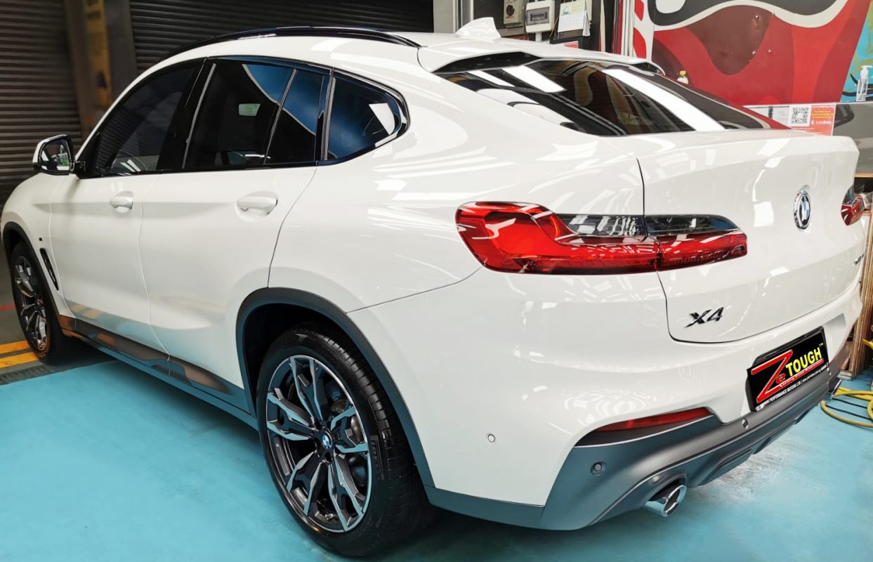 The coated bonnet of the BMW X4 under workshop lighting.