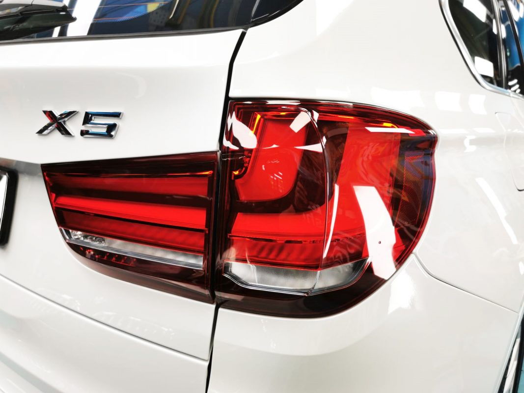 The coated bonnet of the BMW X5 under workshop lighting.
