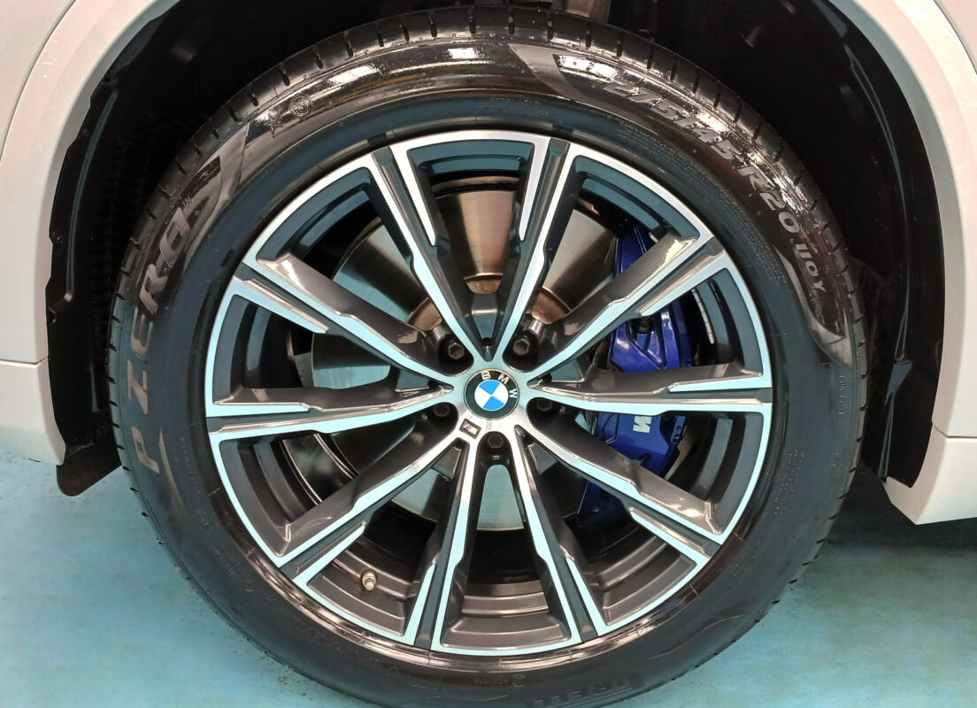 The coated bonnet of the BMW X5 under workshop lighting.