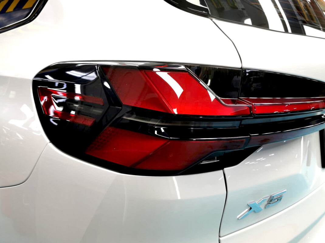 The coated bonnet of the BMW X5 under workshop lighting.