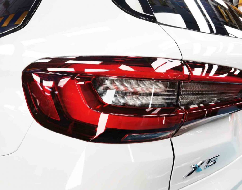 The coated bonnet of the BMW X5 under workshop lighting.