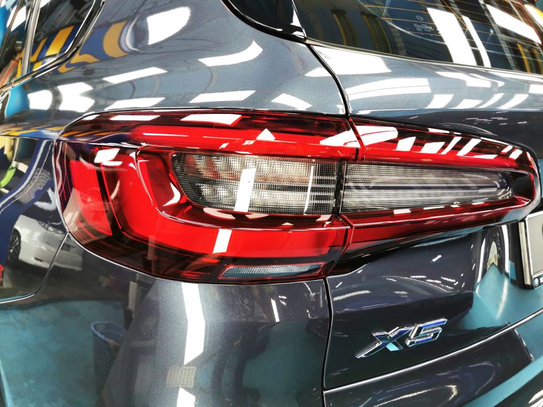 The coated bonnet of the BMW X5 under workshop lighting.