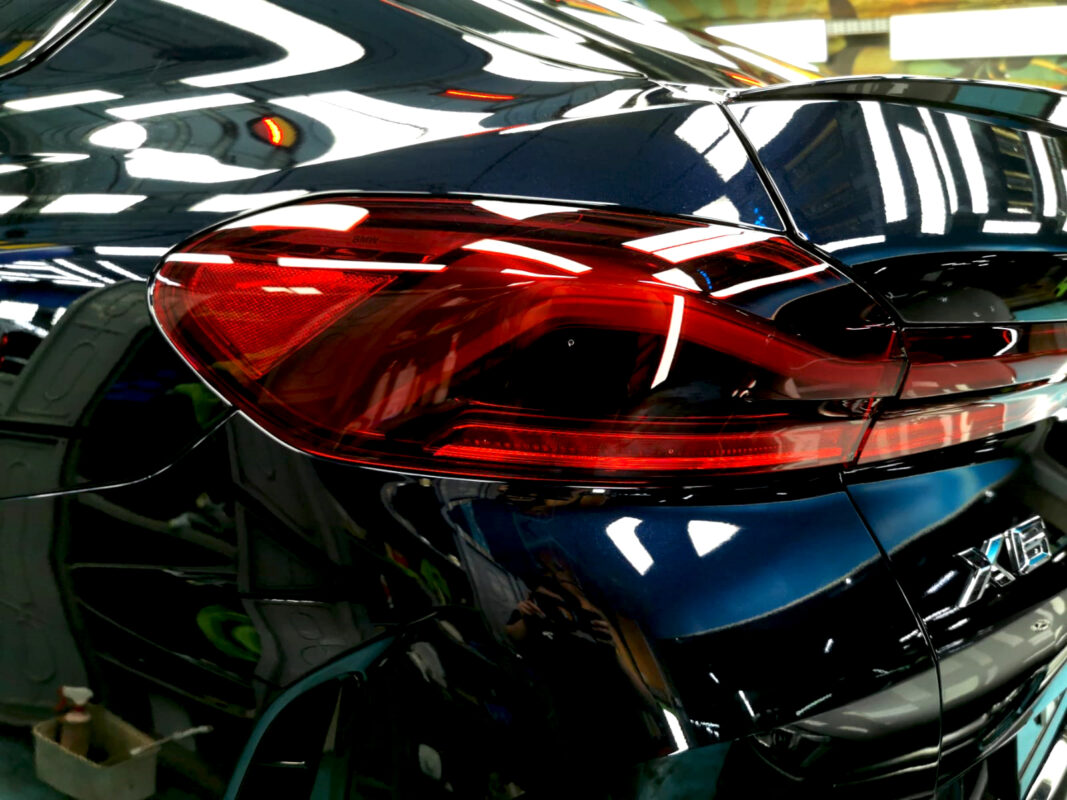 The coated bonnet of the BMW X6 under workshop lighting.