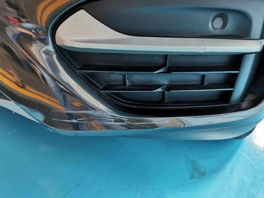 Paint damage detail on the BMW X6, deep scratches and stone chips visible.