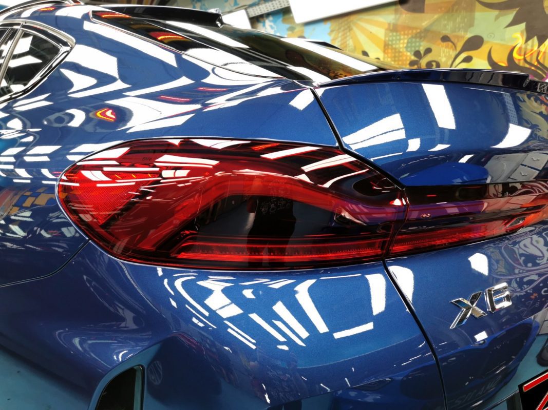 The coated bonnet of the X6 under workshop lighting.