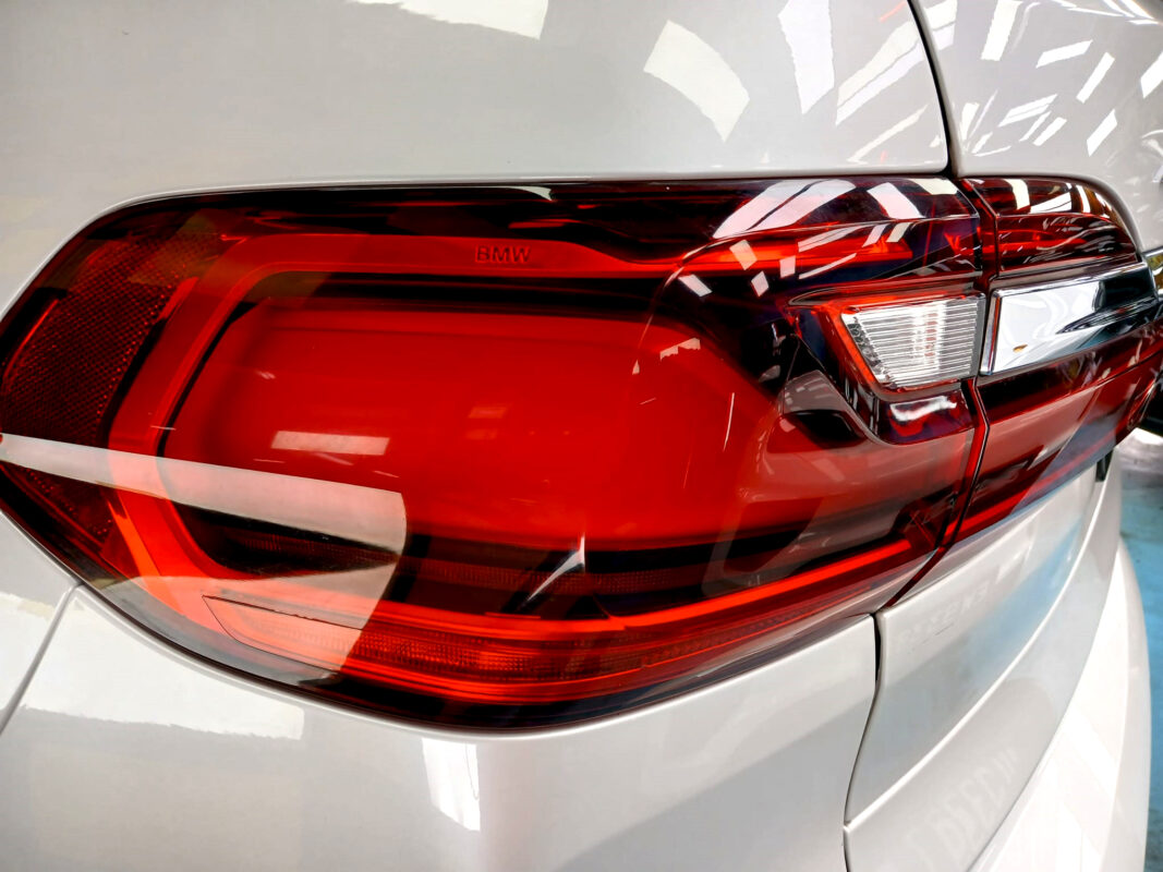 The coated bonnet of the BMW X7 under workshop lighting.