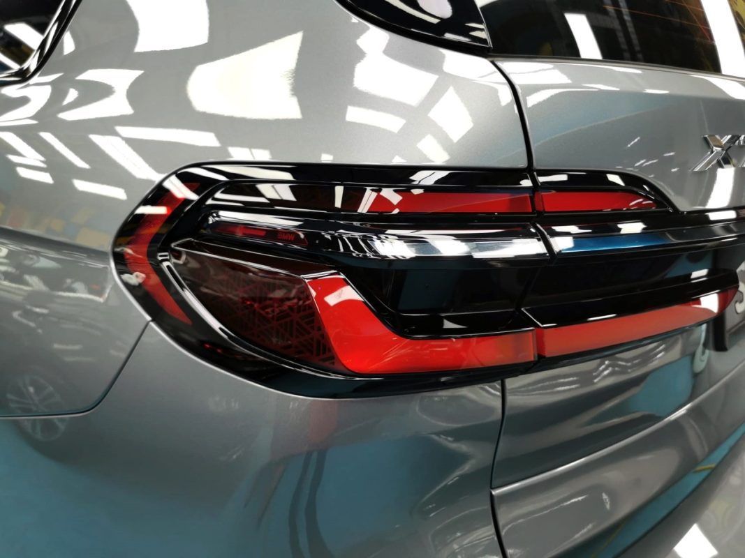 Coated bonnet of the BMW X7 under workshop lighting.