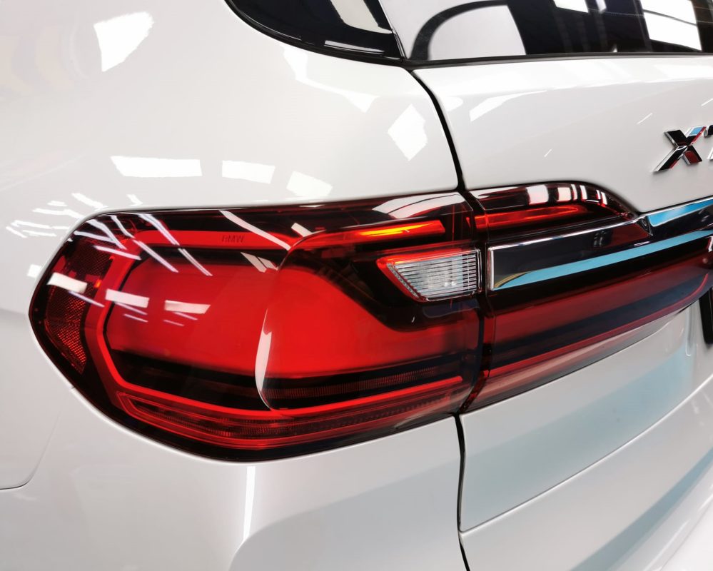The coated bonnet of the BMW X7 under workshop lighting.