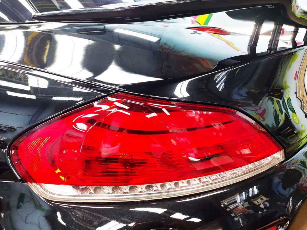 Coated bonnet of the BMW Z4 under workshop lighting.